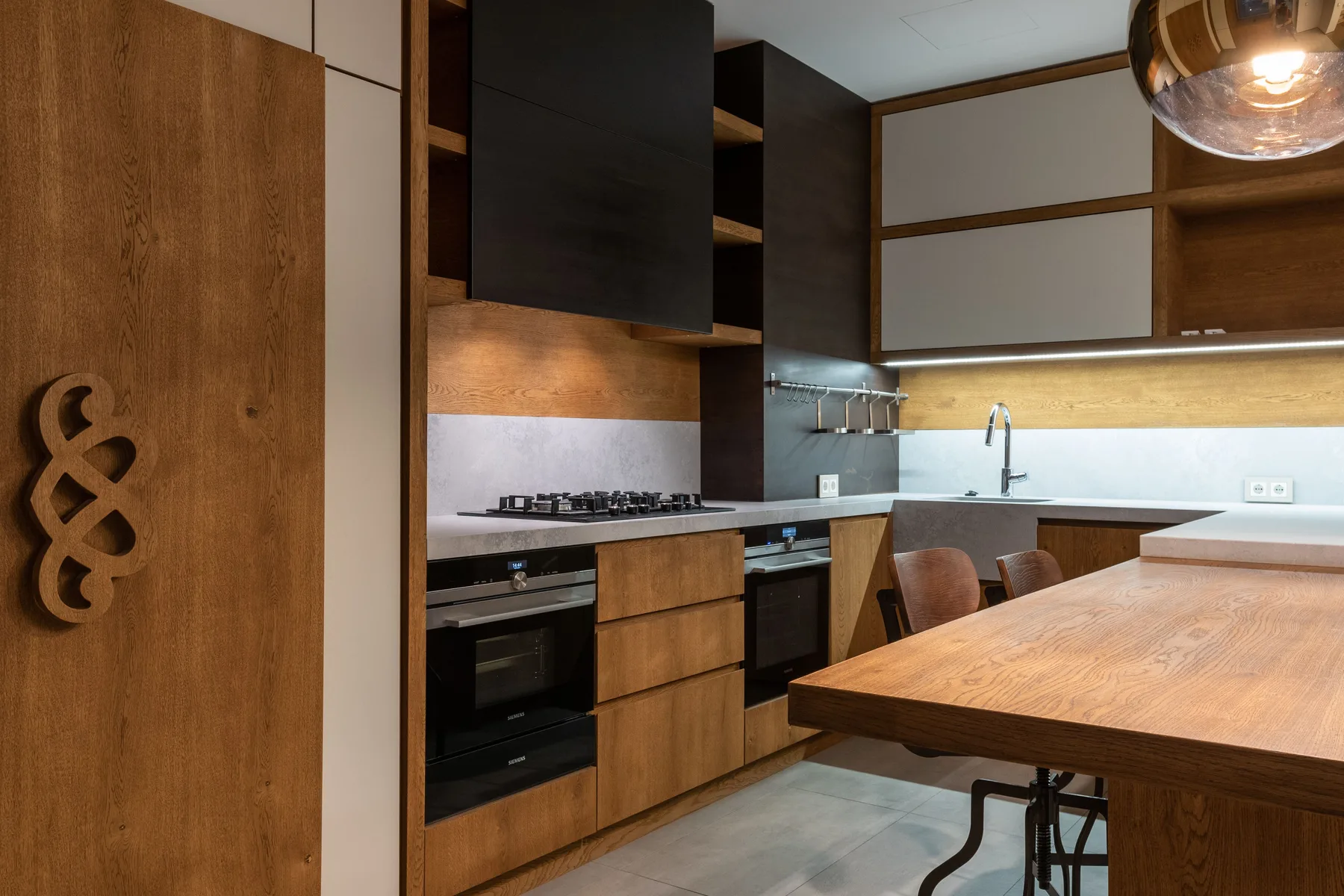 Kitchen with oak fronted base units, a tall painted cupboard run and a stone worktop